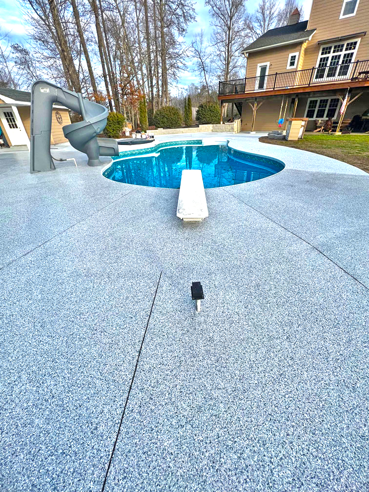 Freshly coated concrete pool deck with textured non-slip finish.