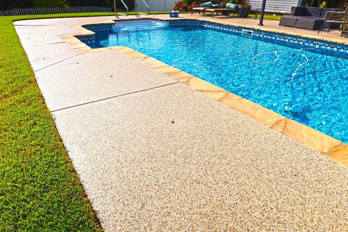a bright blue in ground swimming pool with a new concrete coating by Atlas Coatings in Greenville, SC